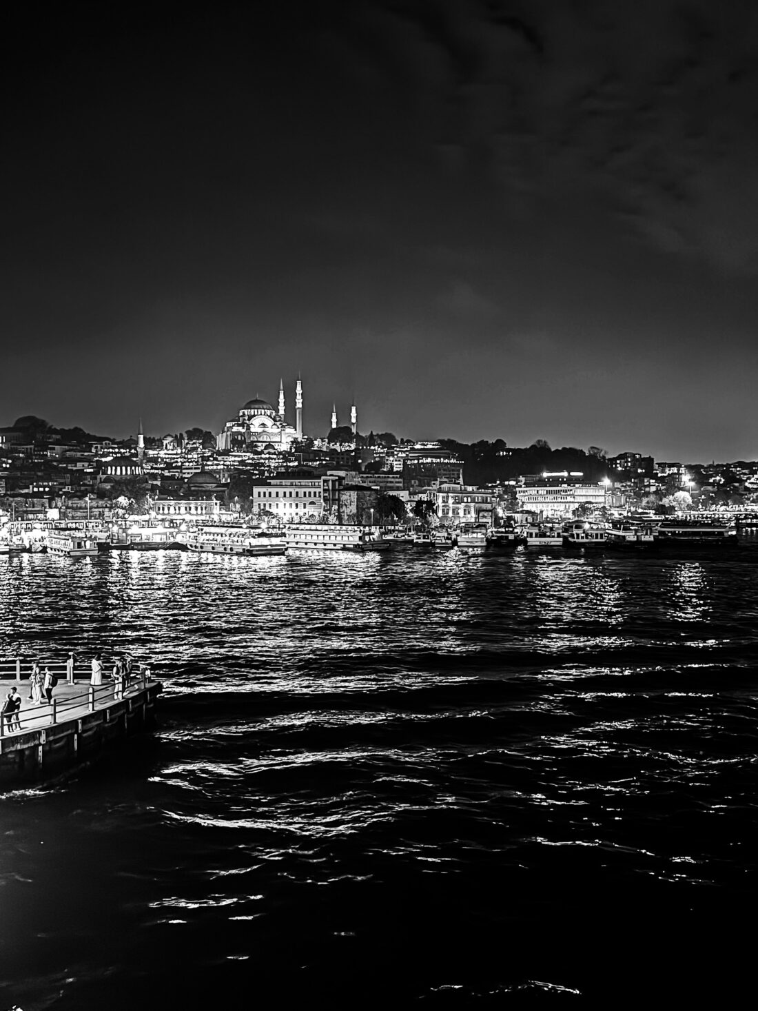 Vista nocturna del Bósforo con la silueta de mezquitas iluminadas.