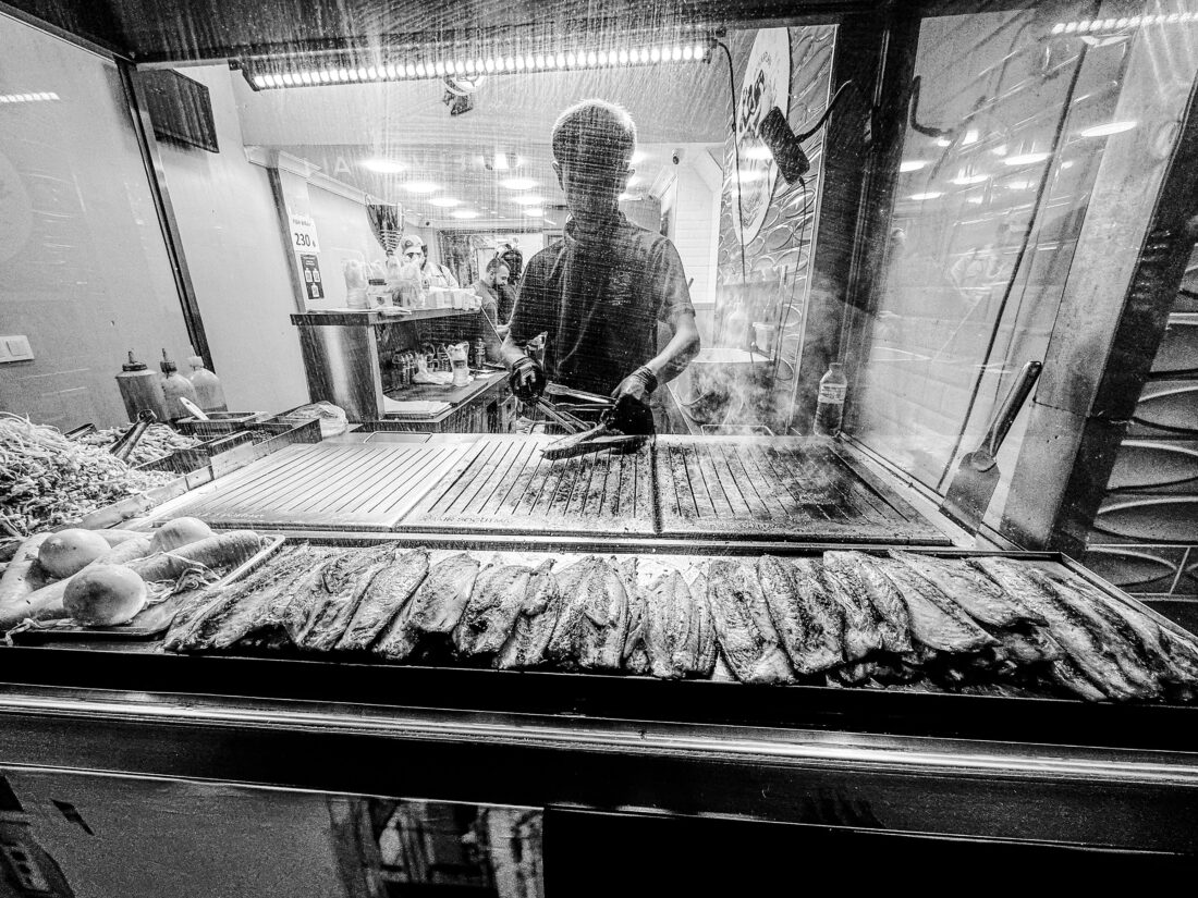 Cocinero preparando pescado en parrilla en el Gran Bazar de Estambul