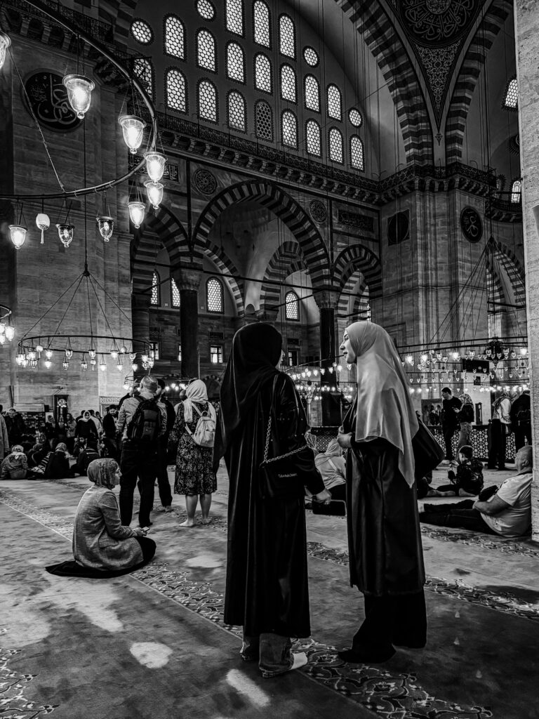 Mujeres en el interior de la Mezquita Süleymaniye en Estambul durante la oración entre columnas y arcos otomanos