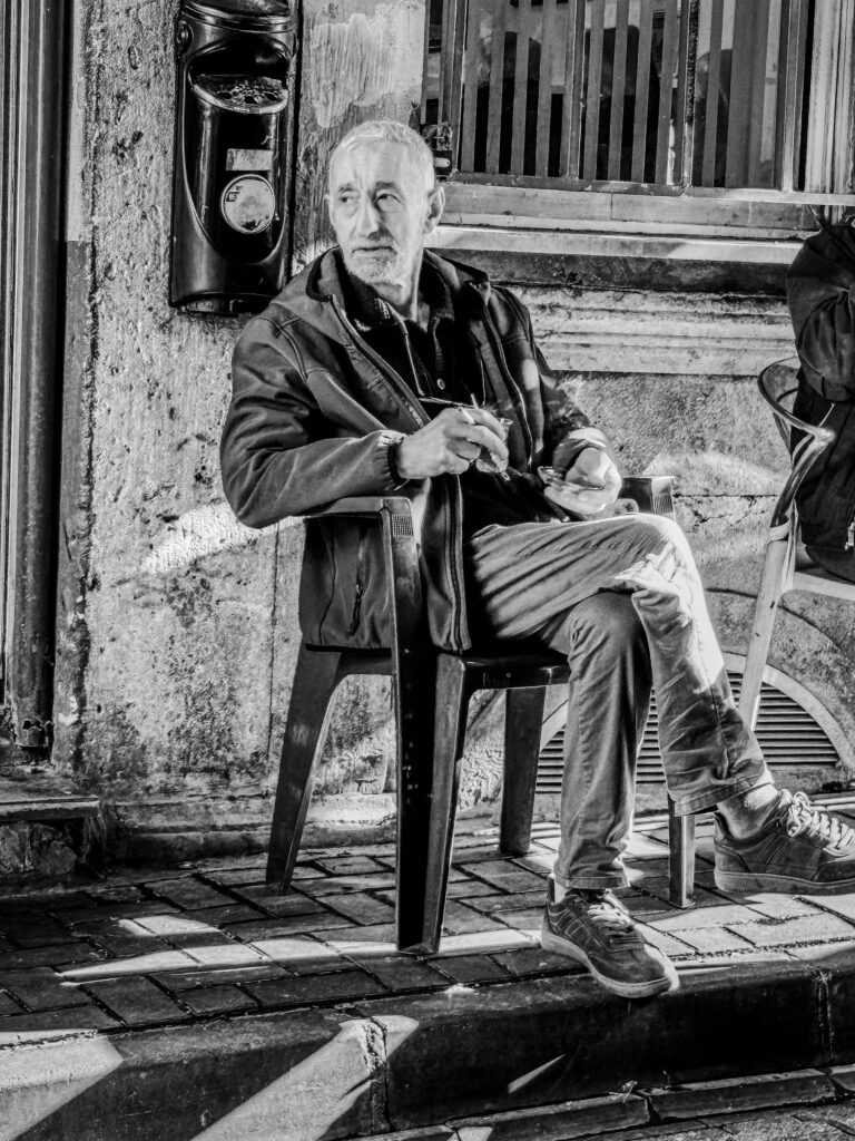 Hombre sentado en una calle de Estambul fumando y descansando