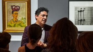 Carlos Segoviano durante un recorrido curatorial en el Museo de Arte Moderno frente a una obra de Frida Kahlo.