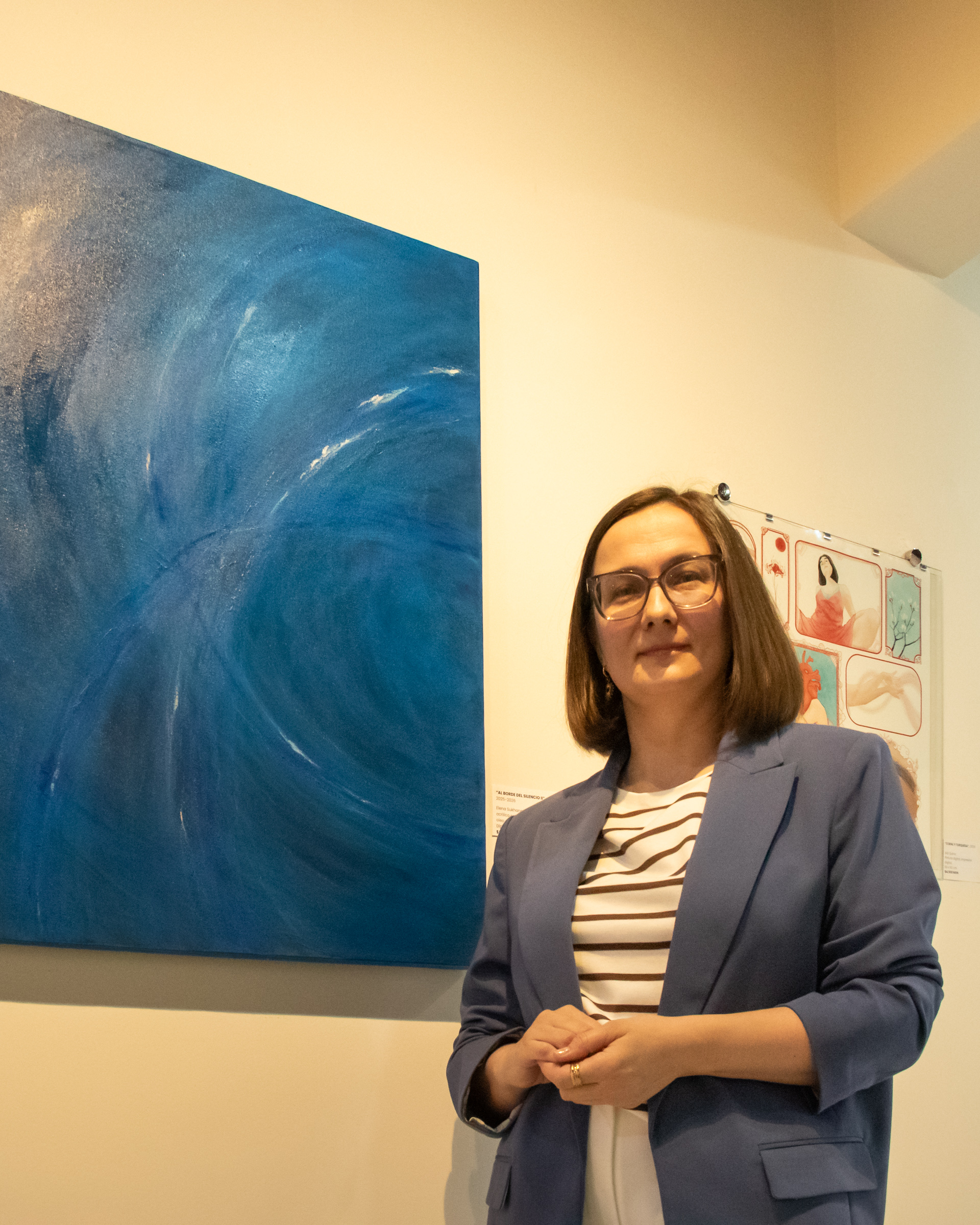 Retrato editorial de Elena Sukhanova junto a una obra azul abstracta en Galería Covarrubias de Ciudad de México.