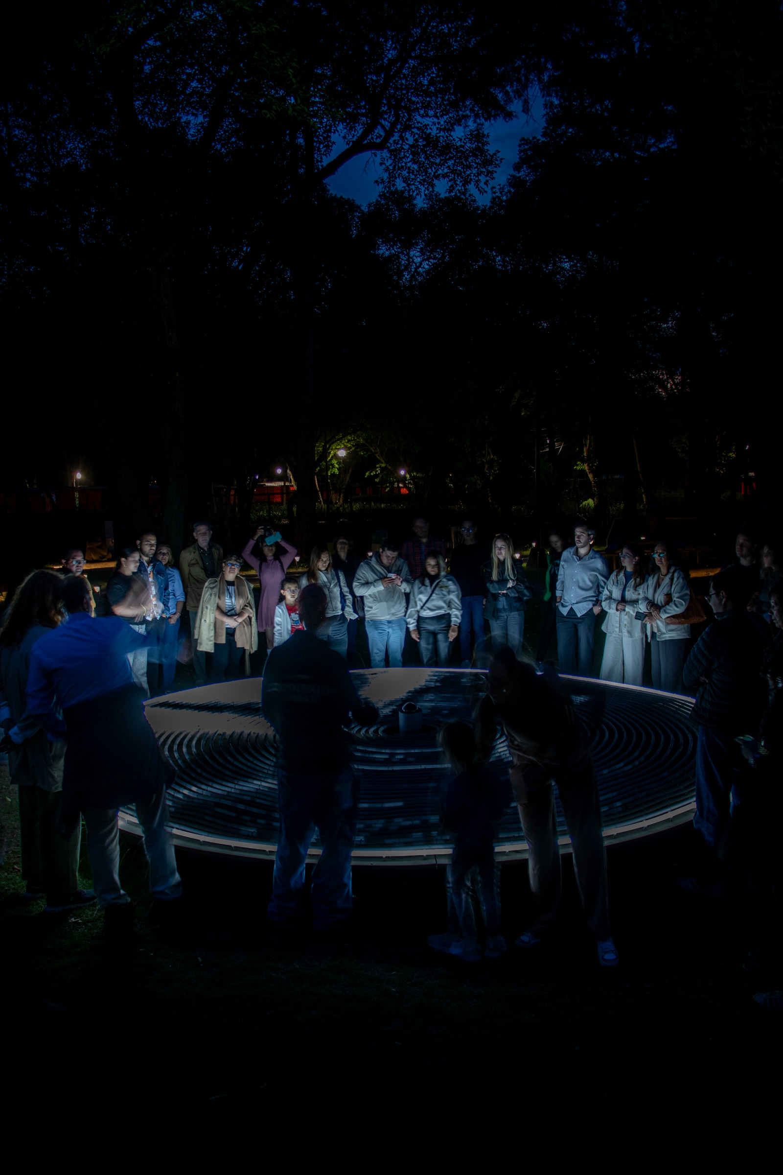 Visitantes reunidos alrededor de una instalación lumínica de Rafael Lozano-Hemmer en Bosque Inconcluso dentro del Museo de Arte Moderno de Chapultepec