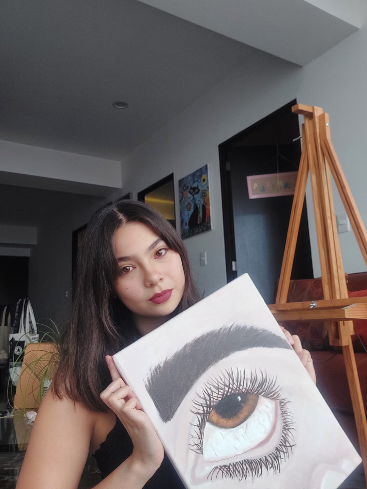 Daniela Milán sosteniendo una de sus obras durante su proceso creativo.