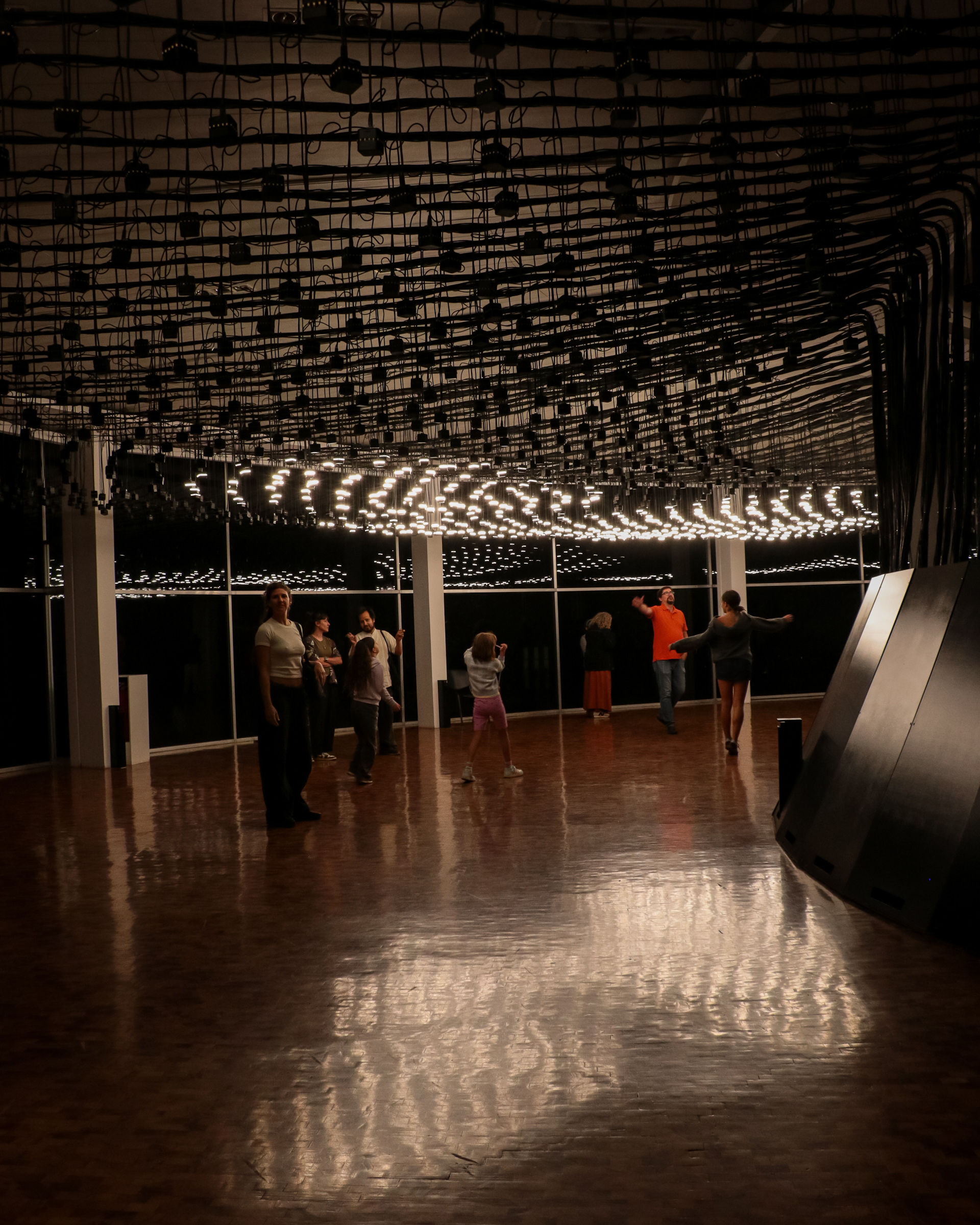 Instalación lumínica suspendida de Rafael Lozano-Hemmer con visitantes en el Museo de Arte Moderno