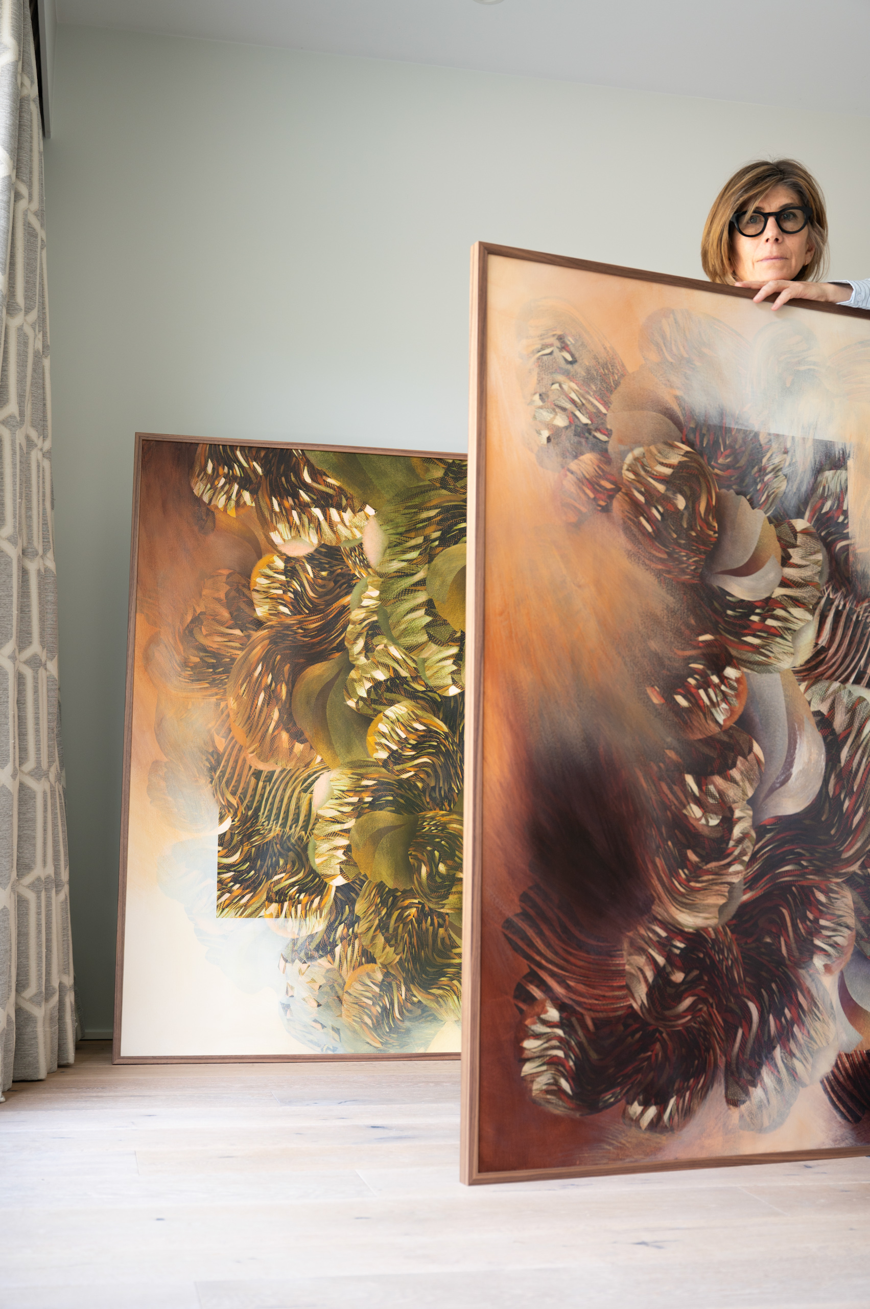 Olga Burkard junto a dos de sus pinturas en su estudio de Ginebra, donde desarrolla sus series de arte contemporáneo.