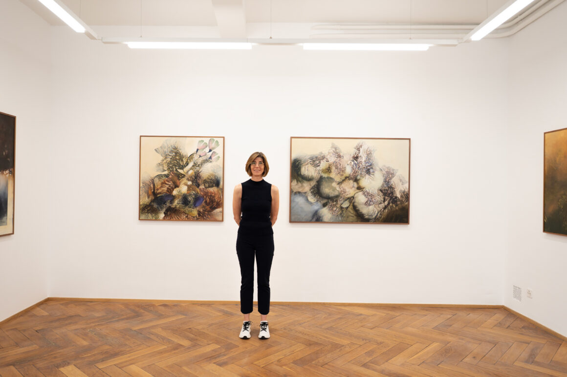 La artista Olga Burkard posa junto a sus obras durante una exposición en Galería Claroscuro, Ciudad de México.