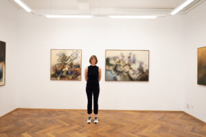 La artista Olga Burkard posa junto a sus obras durante una exposición en Galería Claroscuro, Ciudad de México.