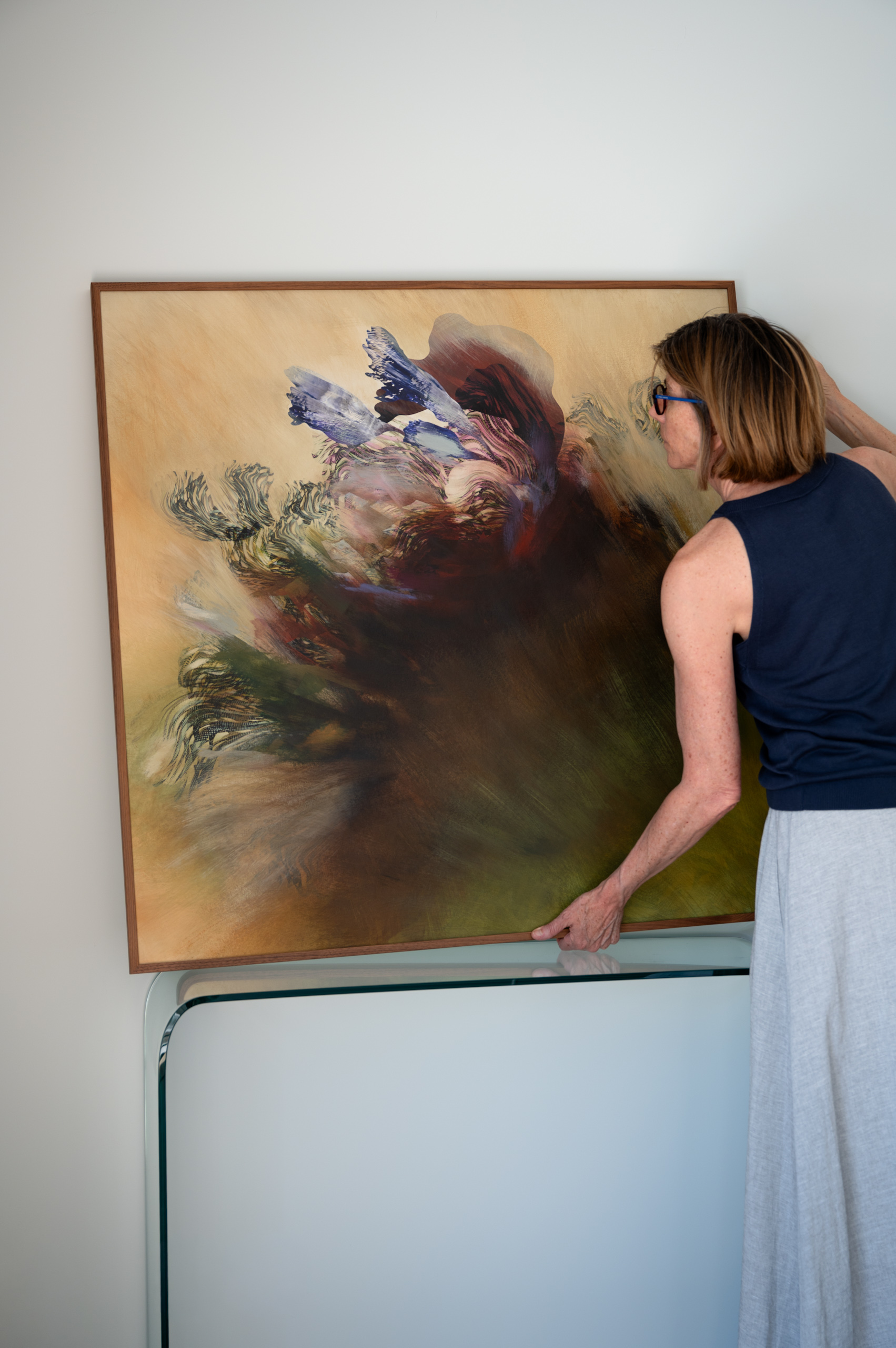 La artista Olga Burkard trabaja en su estudio rodeada de pinturas y procesos de creación visual.