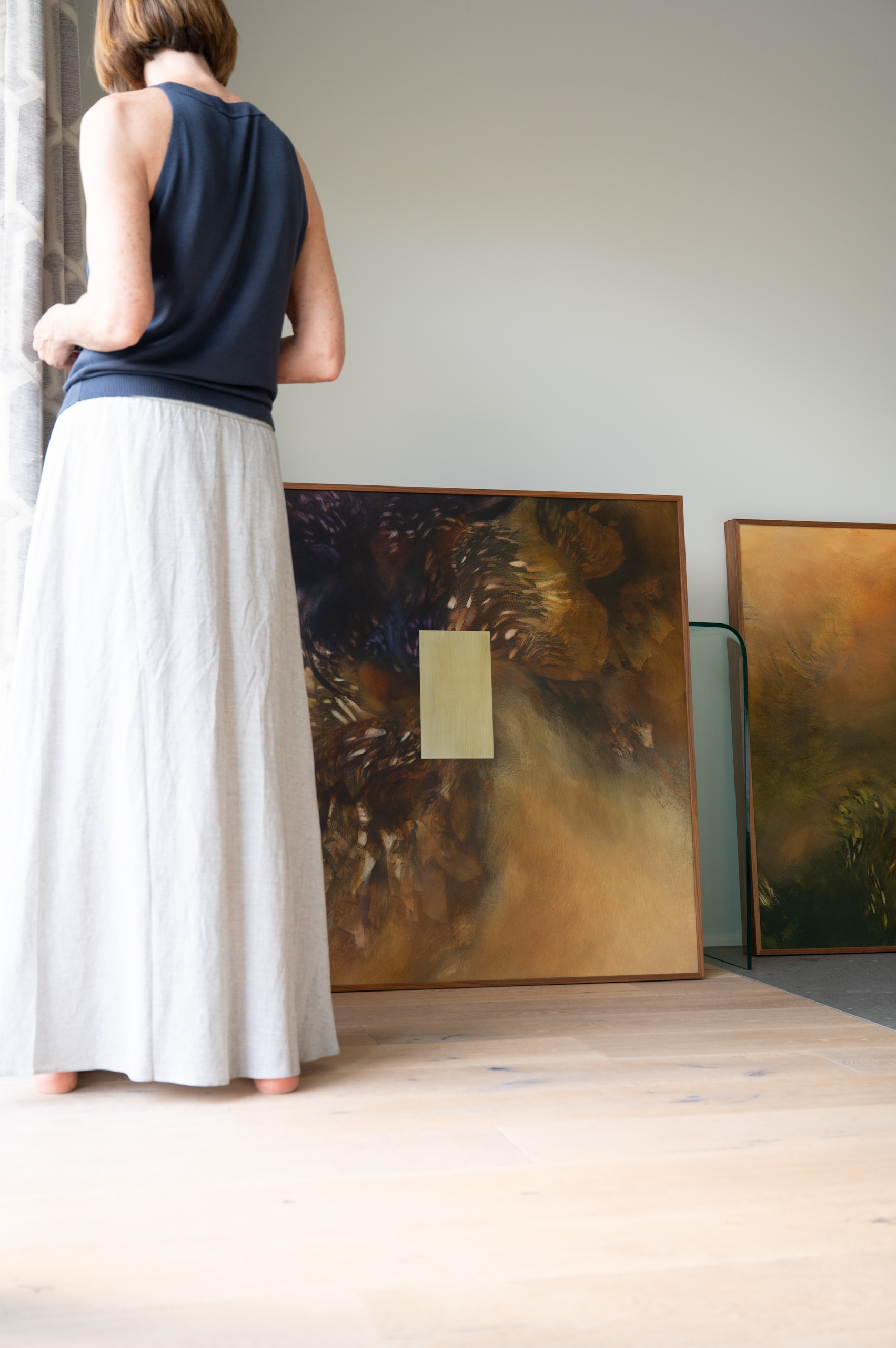 Olga Burkard observa sus pinturas durante el proceso creativo para la exposición presentada en Galería Claroscuro.