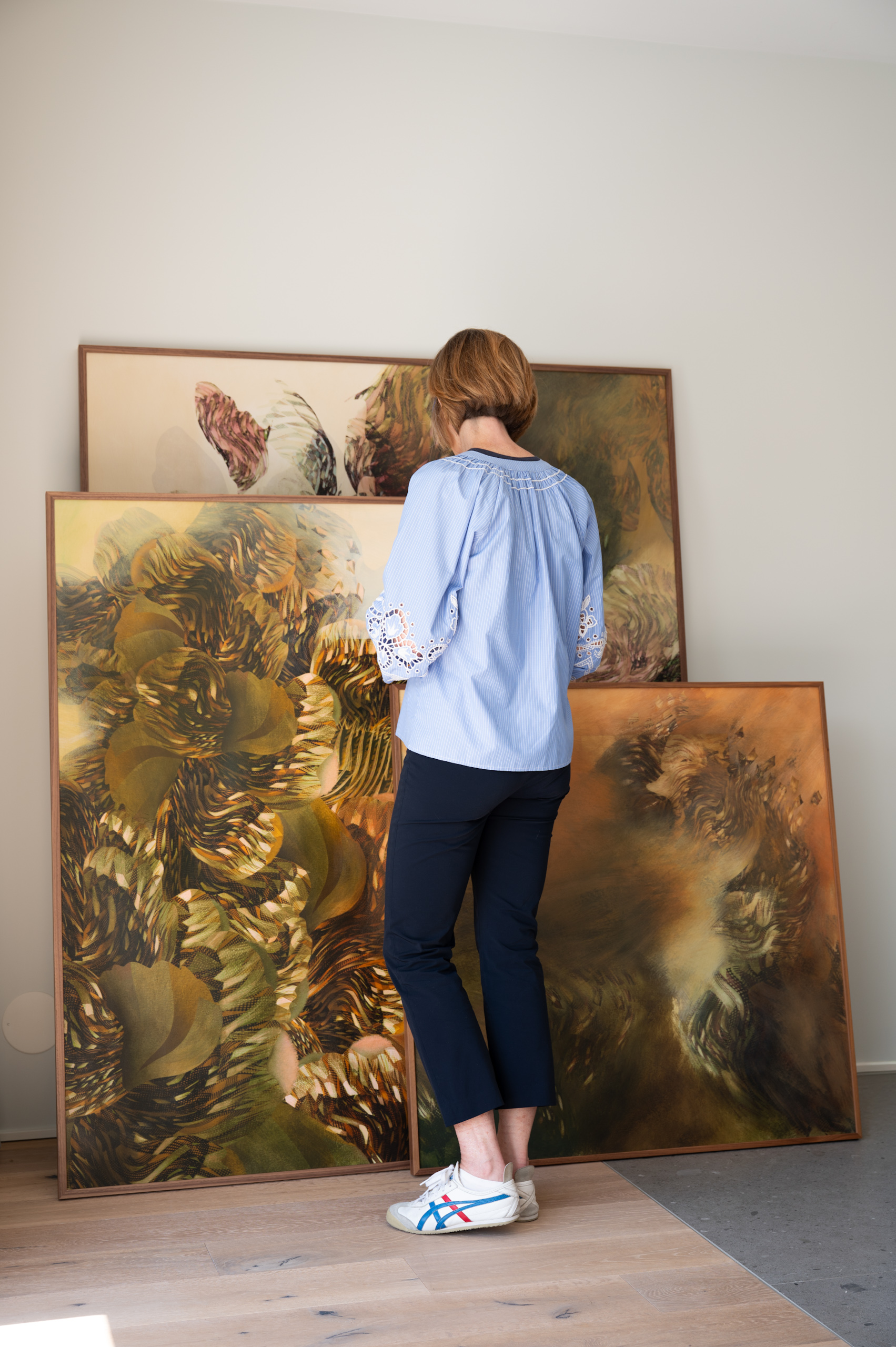 Olga Burkard observa varias de sus pinturas en su estudio de Ginebra durante el proceso creativo.