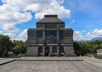 Vista frontal del Museo Anahuacalli bajo un cielo azul con nubes