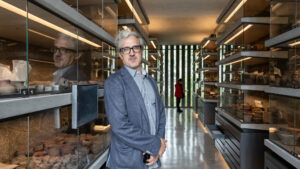 Silvestre Borgatello entre las vitrinas de la Bodega de Colecciones del Museo Anahuacalli, con su reflejo en el cristal.